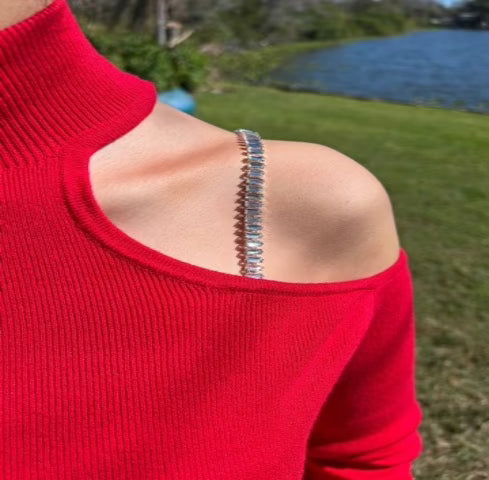 silver bra straps on a shoulder and red sweater